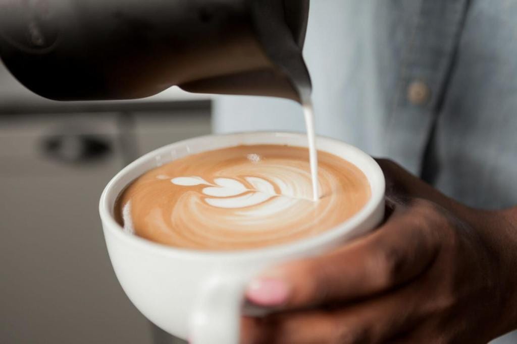 barista pouring a latte